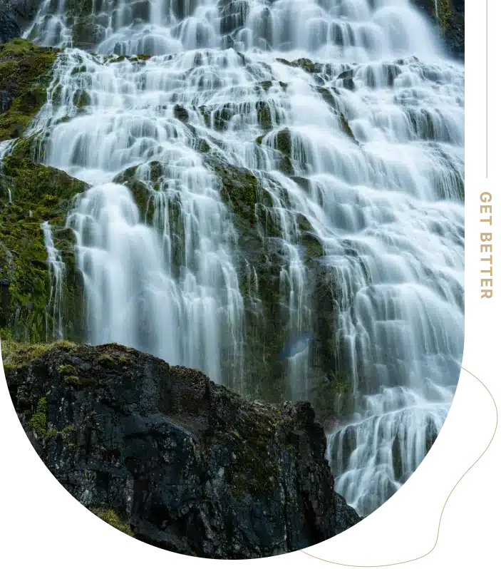A cascading waterfall flows over a rocky cliff.